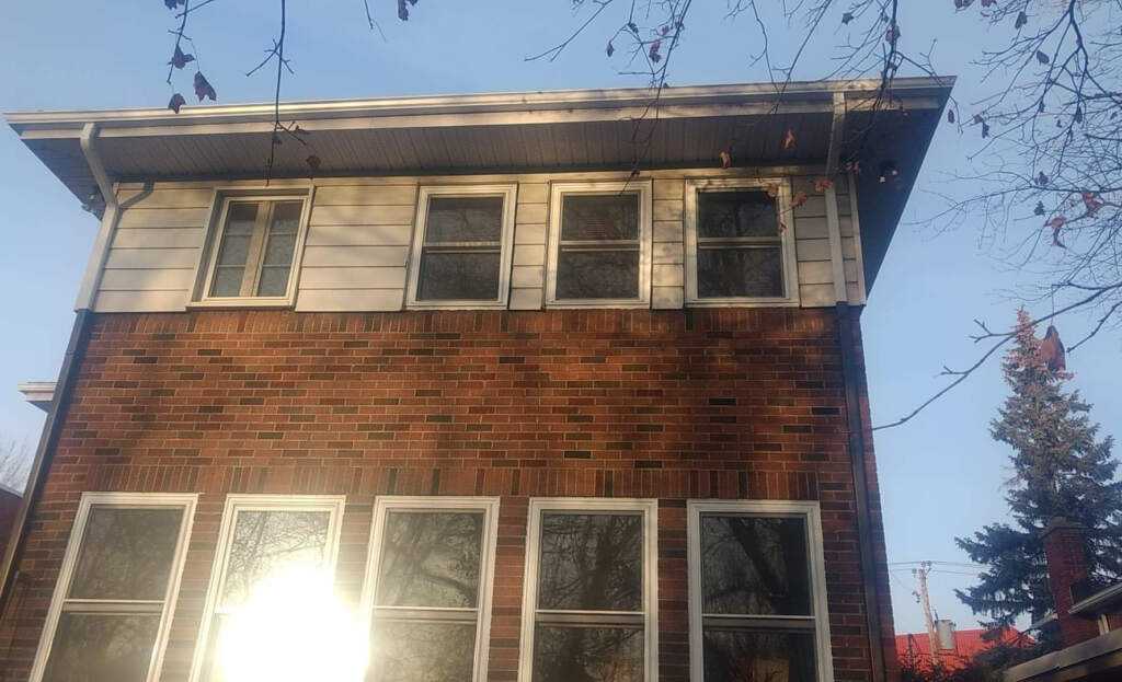 Débord de toit avec gouttière blanche, soffite ventilé et fascia au-dessus d'un déclin — Gouttières et Revêtements Synergy