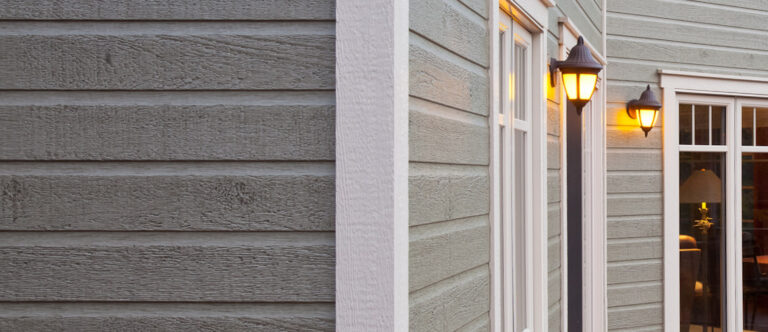 Déclin horizontal gris-vert texturé, moulure de coin et lanternes murales allumées — Gouttières et Revêtements Synergy