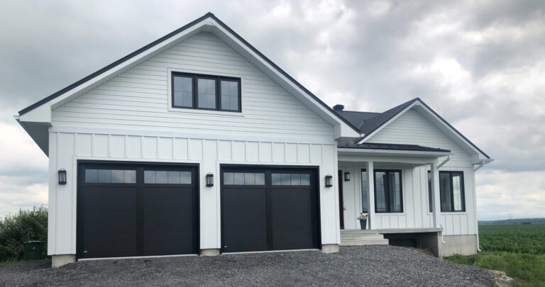 Maison blanche à déclin horizontal et planches verticales, gouttière blanche et descente — Gouttières et Revêtements Synergy