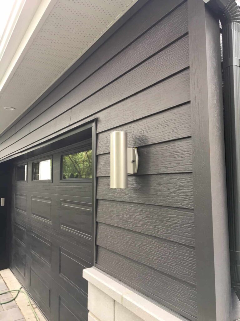 Déclin horizontal gris foncé, soffite ventilé blanc, moulure de coin, descente ronde — Gouttières et Revêtements Synergy
